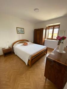 a bedroom with a large bed and a wooden floor at Casa Ermy in Vercana
