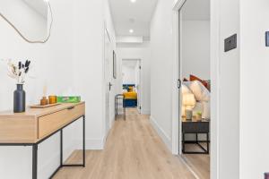 a hallway with white walls and a desk in a room at Stunning 4 Bed, Sleeps 10, Parking in London