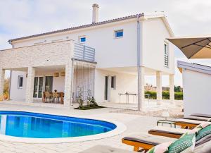 拉宾Villa David - NEW - first renting - for 9 person的一栋房子前面有游泳池的别墅