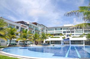 a resort with a large swimming pool and palm trees at #204 Corais de Búzios - Apartamento à beira-mar na enseada de Búzios in Nísia Floresta