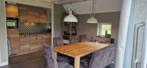 a dining room with a wooden table and chairs at Villa Linde | 4 personen - Vakantiepark De Kremmer in Gasselte