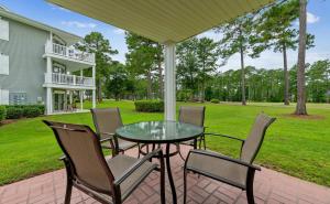 a patio with a glass table and chairs at Relax, Beach, Golf, Shop, Repeat resort in Calabash