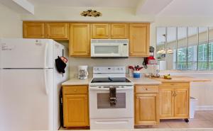 a kitchen with white appliances and wooden cabinets at Relax, Beach, Golf, Shop, Repeat resort in Calabash +18 photos
