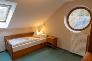 a small bedroom with a bed and a window at Penzión Za Vodou in Oščadnica