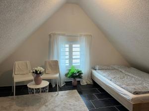 um quarto com uma cama, 2 cadeiras e uma janela em Charming apartment central in Lucerne em Lucerna