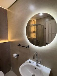 une salle de bain avec un lavabo et un miroir dans l'établissement Апартаменты в 10 минутах от аэропорта Apartments 10 minutes from the airport, à Astana 35 autres photos