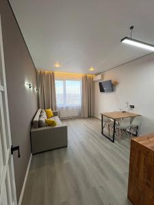 un salon avec un canapé et une table dans l'établissement Апартаменты в 10 минутах от аэропорта Apartments 10 minutes from the airport, à Astana