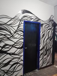una puerta negra con una pintura en la pared en O mago hostel, en Río de Janeiro