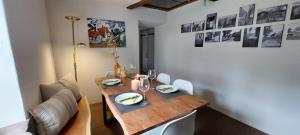 a dining room table with a wooden table and chairs at Ferienhaus mit Baukulturpreis in der Südeifel - Ferienhaus TRÄNK in Bettingen
