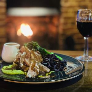 a plate of food on a table with a glass of wine at The White Hart Hotel Witham in Witham