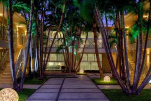a courtyard with palm trees in front of a building at 1818 Meridian House Apartments and Suites by Eskape Collection in Miami Beach