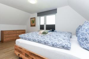 a bedroom with a large bed with a window at Ferienhaus Moorgeist in Stedesdorf