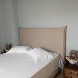 a bed with two white pillows on top of it at Marinas house in Vaia