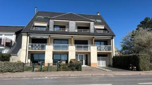 a large house with a balcony on a street at Le Jean Bart front de mer in Le Crotoy