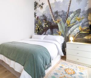 a bedroom with a bed with a tropical wallpaper at Casa Debod in Madrid