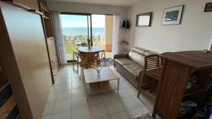 a living room with a couch and a table at Le Jean Bart front de mer in Le Crotoy