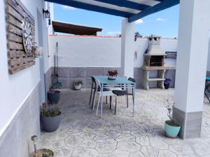 a patio with a blue table and chairs at La magia del sur in Vejer de la Frontera