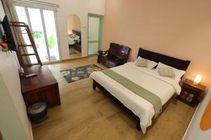a bedroom with a large bed and a mirror at The Balified Villa in Pondicherry