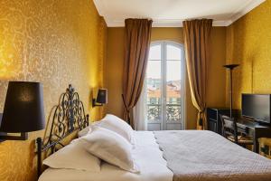 a bedroom with a bed and a window at Hotel Le Grimaldi by Happyculture in Nice