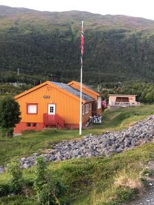an orange building with a flag in front of it at Andsnes Velhus in Loppa