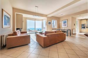 a large living room with two couches and a table at Serenity Villa by Comfortbnb in Saronida