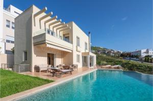 a villa with a swimming pool in front of a house at Serenity Villa by Comfortbnb in Saronida