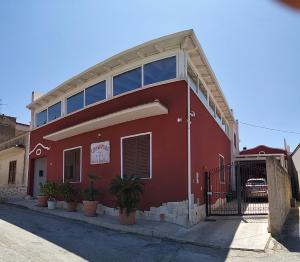 a red building with plants in front of it at Cofanomare in Custonaci