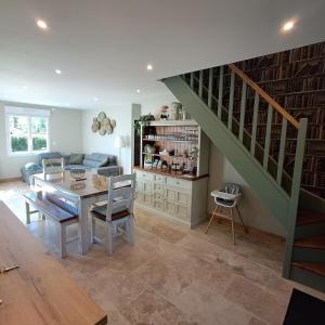 a living room with a table and a staircase at Proche châteaux de la Loire zoo Beauval gite de sologne 3 étoiles in Pruniers