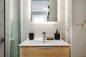 a bathroom sink with a mirror and a shower at Eirini & Nicol Studios by Cretanhouses in Thérissos