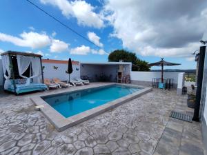 a villa with a swimming pool and a patio at LAS TRES ROSAS in Vejer de la Frontera