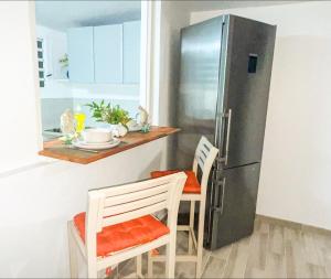 a kitchen with a refrigerator and a table and chairs at Charmant Studio Cosy Amatera in Fort-de-France