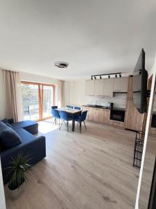 a living room with a blue couch and a table at Lake Apart Residence in Osłonin