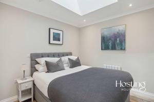 1 dormitorio con 1 cama grande y 2 cuadros en la pared en The Courtyard Apartments - Rosemary, en Henley on Thames