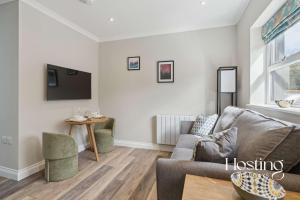 una sala de estar con un sofá y una mesa en The Courtyard Apartments - Rosemary, en Henley on Thames