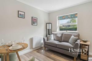 una sala de estar con un sofá y una mesa en The Courtyard Apartments - Rosemary, en Henley on Thames