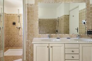 a bathroom with two sinks and a shower at Hotel Le Grimaldi by Happyculture in Nice