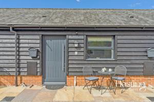 una casa con una puerta, 2 sillas y una mesa en The Courtyard Apartments - Rosemary, en Henley on Thames