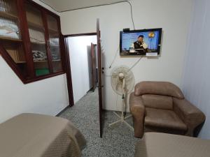 a room with a fan and a chair and a tv at Suculento Apart in Fray Bentos