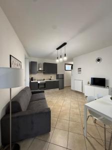a living room with a couch and a kitchen at Appartamento turistico benessere in Castiglione dei Pepoli