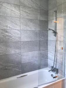 a bathroom with a shower with a bath tub at Belmont Chapel Cottage in Acharacle