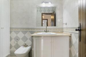 a bathroom with a sink and a toilet and a mirror at Casa Huerta 1 in Conil de la Frontera +13 photos