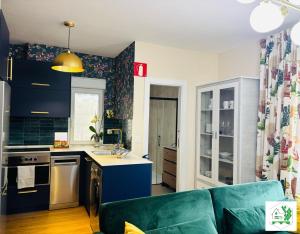 a living room with a green couch in a kitchen at Bilbao La Vieja Arena WIFI in Bilbao