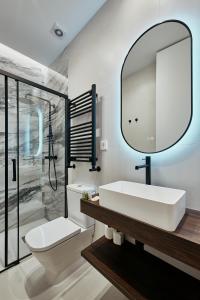 a bathroom with a sink and a toilet and a mirror at Fuencarral Living 7BR 7BH in Madrid