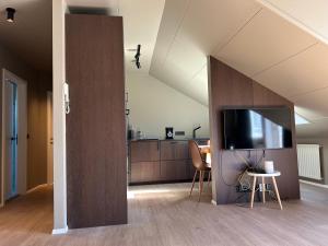 a living room with a tv and a kitchen at G10 Apartments in Akureyri