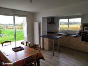 a kitchen and dining room with a table and a view of a field at Maison dans les vignes - proche Chenonceau Beauval in Saint-Georges-sur-Cher +8 photos