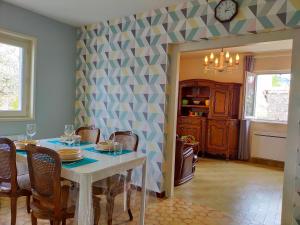 a dining room with a white table and chairs at Chez Tata Malou - Maison avec jardin, cour fermée, proche toutes commodités in Saint-Julien-Chapteuil