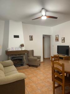 a living room with a couch and a television and a table at Casa San Marcos in El Hornillo