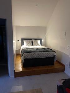 a bedroom with a bed on a wooden platform at Le Studio in Goussainville