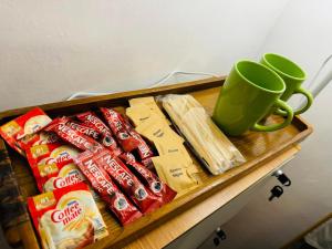 een dienblad met snacks en een groene koffiemok op tafel bij Fazzah De Siargao in General Luna