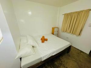 een teddybeer op een bed in een kamer bij Fazzah De Siargao in General Luna